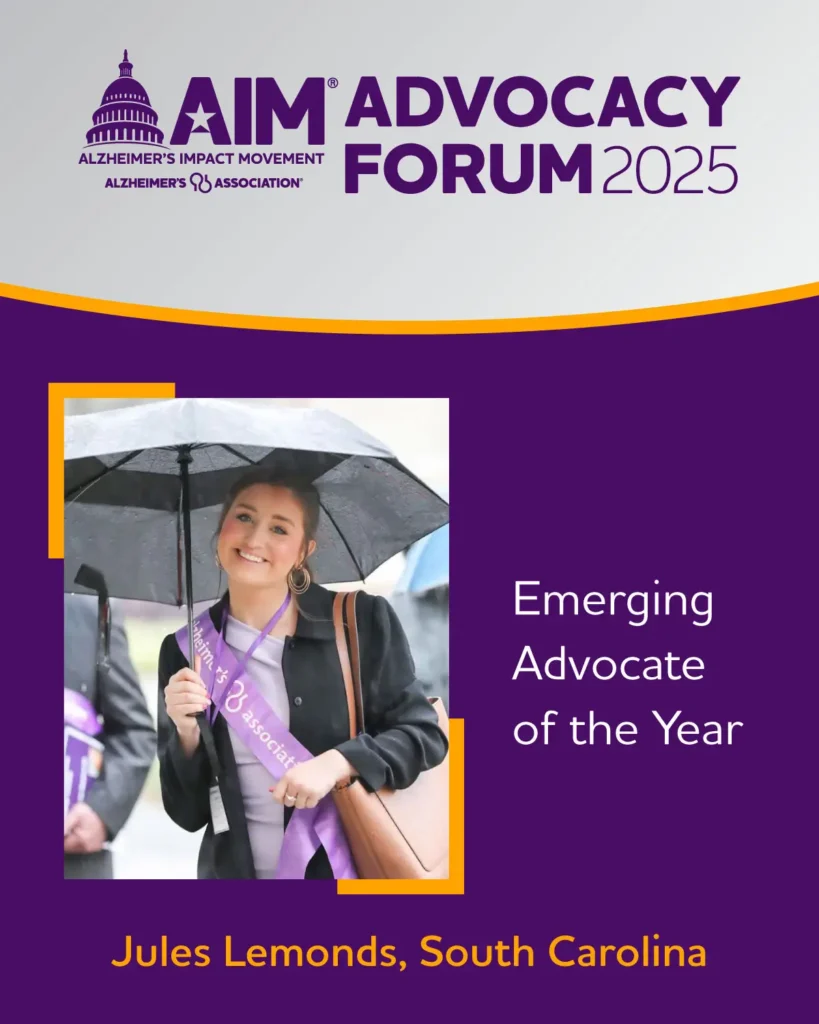Smiling woman holding umbrella and wearing purple sash, named Emerging Advocate of the Year, Jules Lemonds.